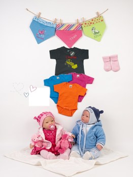 Personalisierte Babykleidung: Babypuppen in Rosa und Blau, bunte Bodys, besticktes T-Shirt und Halstücher vor weißem Hintergrund.