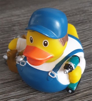 Ente Handwerker im blauen Arbeitsoutfit mit Werkzeugkoffer und Akkuschrauber