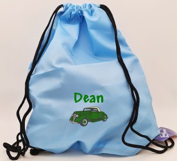 Hellblauer Turnbeutel mit grün gesticktem Namen Dean und grünem Oldtimer als Stickmotiv, mit schwarzen Tragekordeln