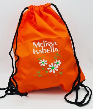 Orangefarbener Turnbeutel mit weiß gesticktem Doppelnamen Melissa Isabella und drei weißen Blumen mit grünen Blättern und Ranken
