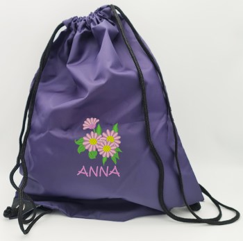 Violetter Turnbeutel mit rosa gesticktem Namen Anna und Blumenmotiv aus rosafarbenen Blüten mit gelben Blütenmitten und grünen Blättern